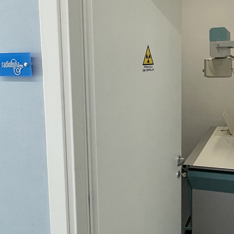 Una porta in primo piano che porta dentro la stanza dove vengono svolte le radiografie al centro veterinario montecchio